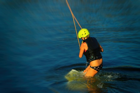 Wakeboarding. Young veykbordistov holding hands on the rope above the water. Water sports