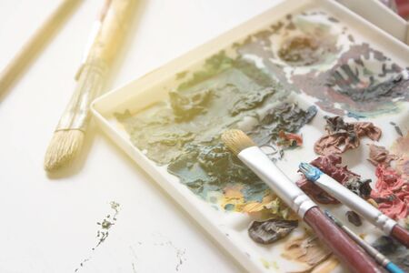 Artists brushes and old palette with oil paints, drawing and creativity. Tonedの写真素材