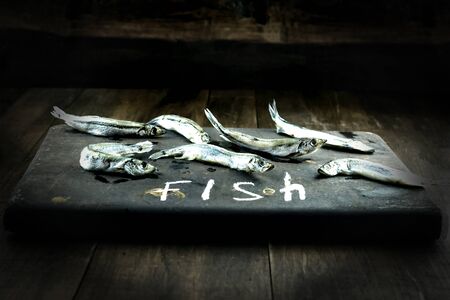 Seafood. Small sea fish, anchovies, capelin, smelt, on dark background Fish patternの写真素材
