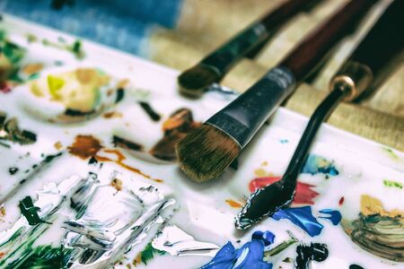 Artists brushes and old palette with oil paints, drawing and creativity. Tonedの写真素材