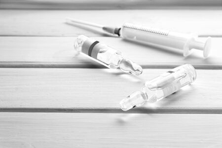 5ml medical syringe and glass ampoules for injection on white wooden background Vaccine and vaccinationの写真素材