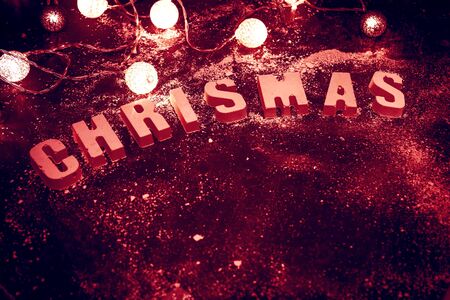 Word of the letters Christmas made of concrete, on a dark background and Christmas garland. Vintage...