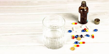 Close-up of bright colored medical tablets, a bottle of medicine and capsules with medicines and a...