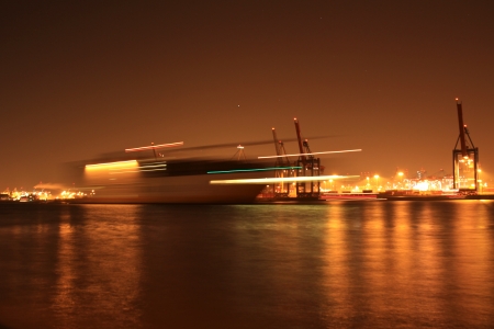 a ship in the night in the harbor of hamburgの写真素材