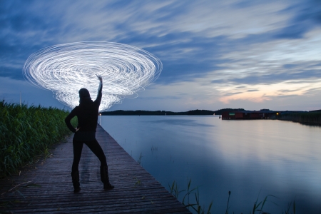 a women in the sunset who play a light gameの写真素材