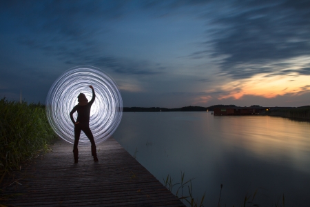 a women in the sunset who play a light gameの写真素材