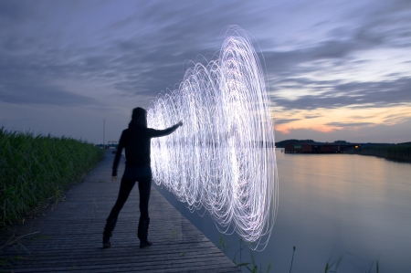 a women in the sunset who play a light gameの写真素材