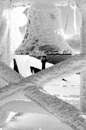 a bell in the snowy winter on the mountainの写真素材