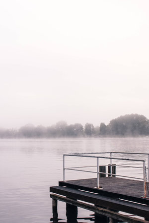 a lake bank on a foggy october morningの写真素材