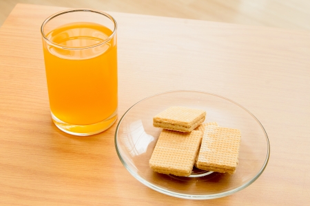 Orange juice and Wafer on the wooden tableの写真素材