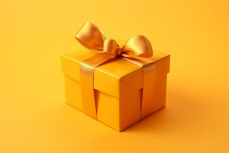 Gift box with golden satin ribbon and bow on yellow background. Holiday gift with copy space. generative aiの素材