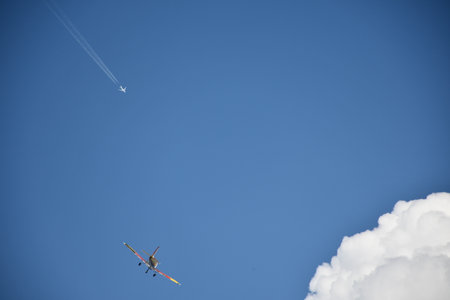 Airplane in the blue sky with white clouds on a sunny dayの写真素材