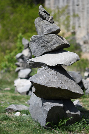 A vertical stack of rugged stones arranged carefully in nature, symbolizing balance and harmony. Captured outdoors with soft background blur.の写真素材