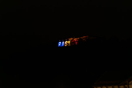 RASNOV Sign Illuminated in Romanian Flag Colors on Citadel Hill at Nightの写真素材