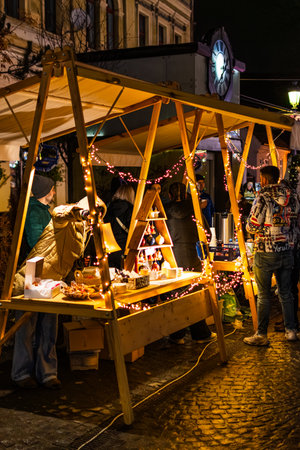 Customers shopping at illuminated Christmas Market Vendor Stall at Nightのeditorial素材