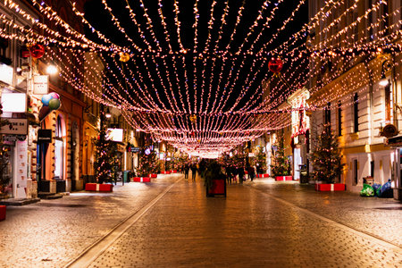 Pedestrian Republicii street in Brasov, Romania, decorated with warm Christmas lights and ornaments...