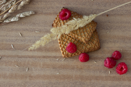 cookies with raspberries and ears on wooden tableの写真素材