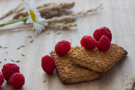 cookies with raspberries and ears on wooden tableの写真素材