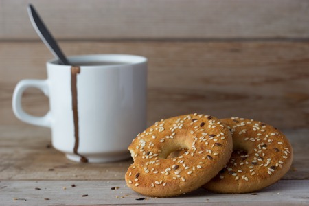 round cookies and cup of coffee on wooden tableの写真素材