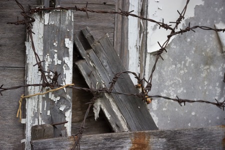 old abandoned grey wooden fence barbed wire