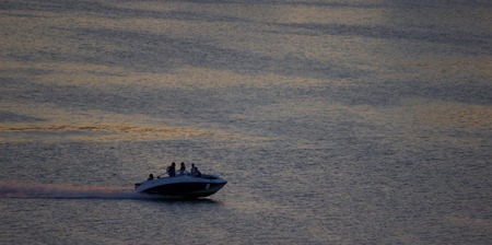 distant motorboat on the sea, evening darkの写真素材
