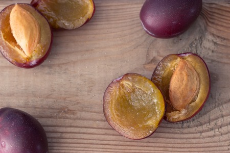 ripe plums on the wooden table, close upの写真素材