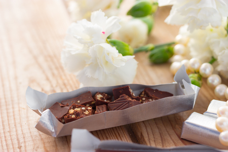 Romantic St Valentine's setting with chocolate necklace and white flowersの写真素材