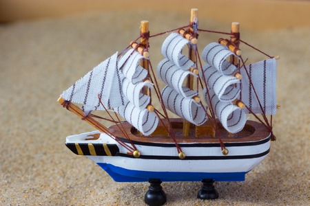 toy of a sailing ship in a sandの写真素材
