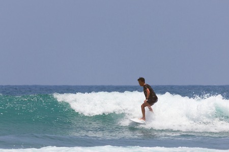 10.04.2017: Sri Lanka, Mirissa: Single surfer at sunset in the ocean with wavesのeditorial素材