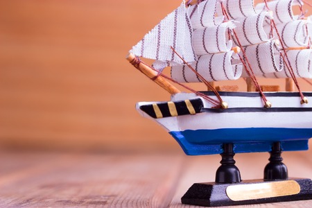 Toy sailboat on a wooden background with copy spaceの写真素材