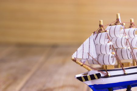 Toy sailboat on a wooden background with copy spaceの写真素材