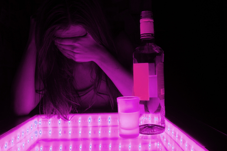 young woman cry. alcohol beside her. depression, problems conceptの写真素材