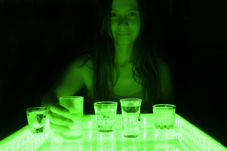 woman on a date in a club, sitting at the table with alcohol drinksの写真素材