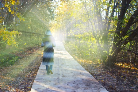 person in a hood walking toward the light. lidht in the end of the tunnel. clinical death conceptの写真素材
