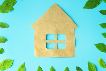 paper house on blue background with leavesの写真素材