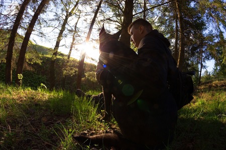 unusual shot of men and his dog in a forestの写真素材