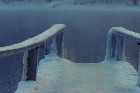 frozen wooden bridge in a lake. very sliperyの写真素材