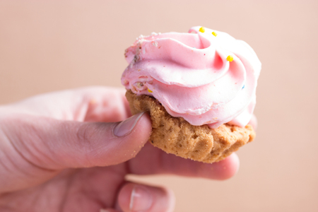 pink cupcake in a hand. close upの写真素材