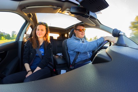 man and woman in sunglasses in the car. travel by car concept