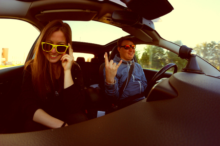 man and woman in sunglasses in the car. travel by car concept