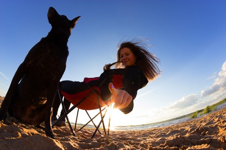 girl in beach chair with dog on the beachの写真素材