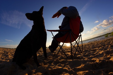 man and his dog relax on the beachの写真素材