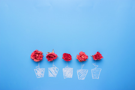 dry Rose placed on the desk in blue background