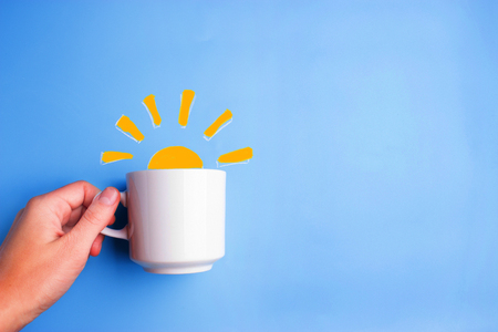 sun and white cup on blue background. good morning conceptの写真素材