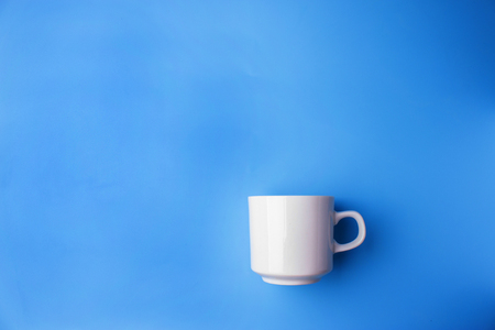 white cup on blue background with copy spaceの写真素材