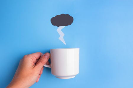 rain pouring in coffee cup on blue backgroundの写真素材