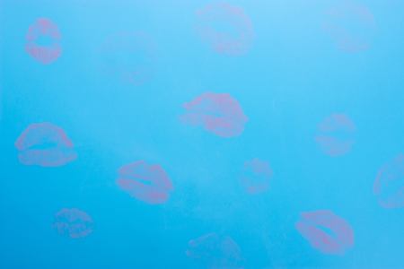 Red print of female lips on blue backgroundの写真素材