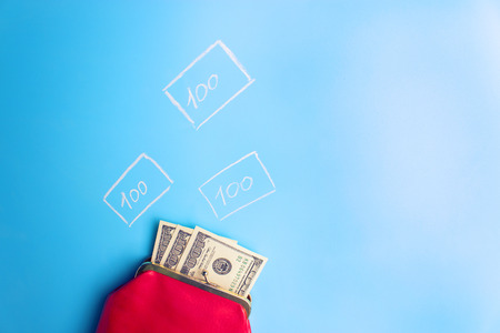 red leather wallet with money on blue backgroundの写真素材