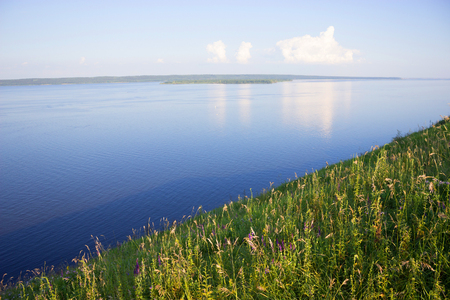 Ripples on the river at sunny summer day. green grassの写真素材