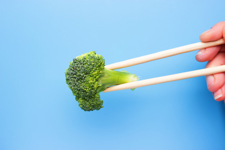Raw and fresh healthy broccoli cabbage on blue backgroundの写真素材